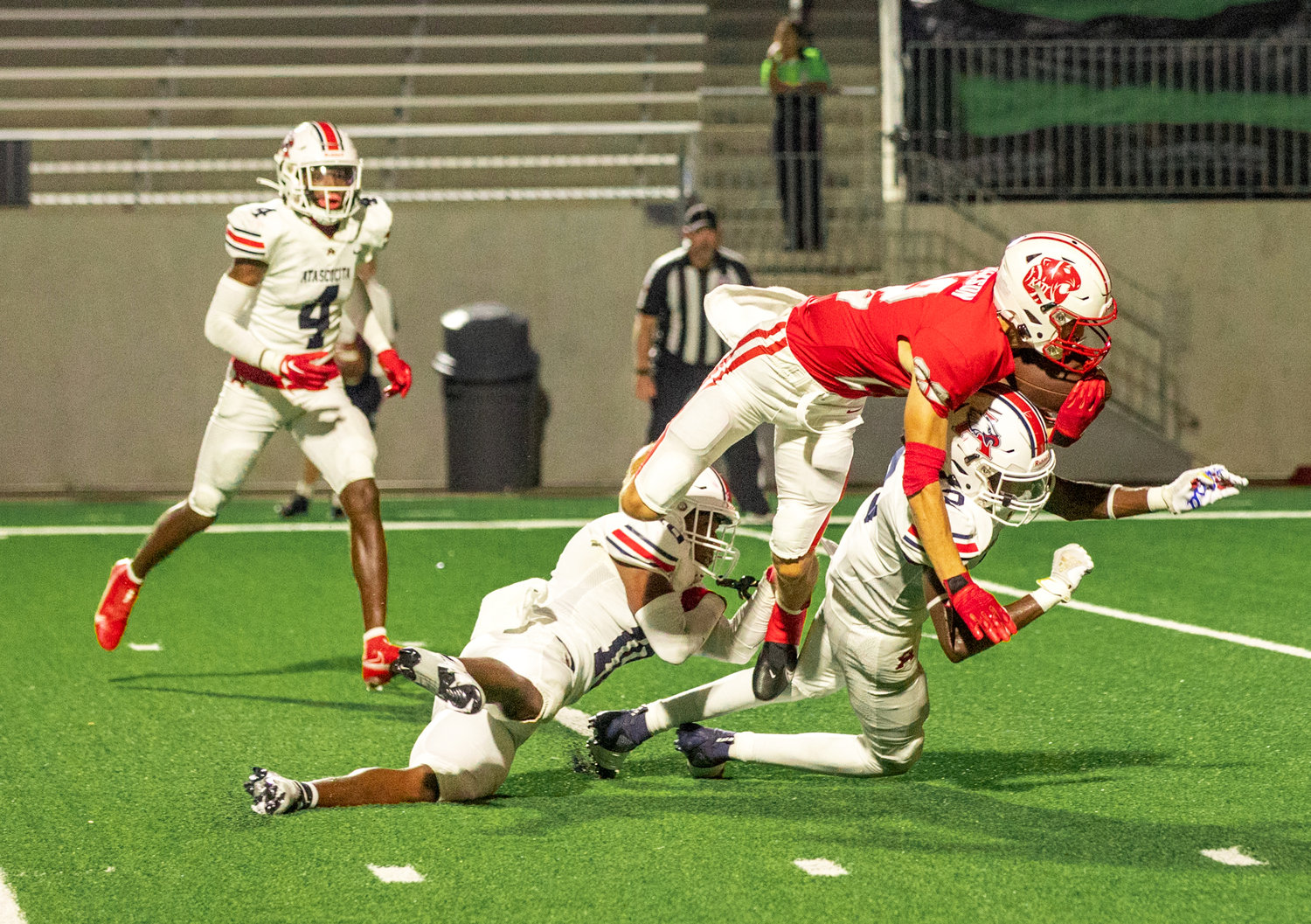 Katy’s Adam Jackson dives over Atascocita defenders to score a touchdown during Friday’s game between Katy and Atascocita at Legacy Stadium.